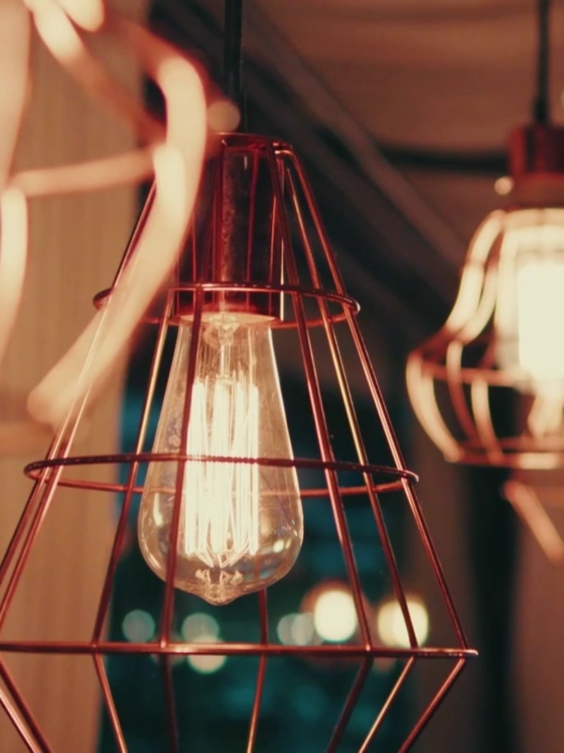 Luminárias pendentes acesas sobre o salão do restaurante